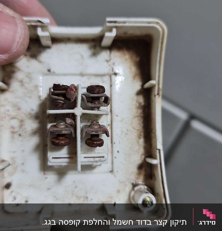 חיבורי חשמל עם חלודה בתוך שקע פלסטיק